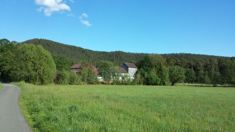 Wassermühle umgeben von Bachlauf und Wiesen