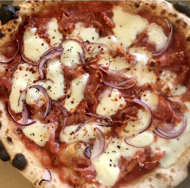 La pizza Braz (sauce tomate, mozzarella fior di latte, spianata piccante, oignons rouges, piment doux).
(Nossa Pizzeria Sète)