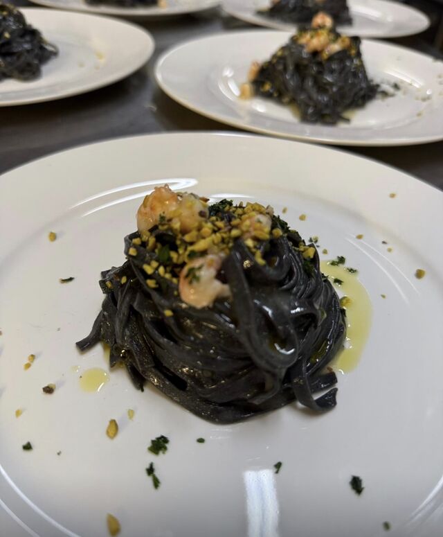 Linguine al nero di seppia , bisque di scampi e pistacchi 