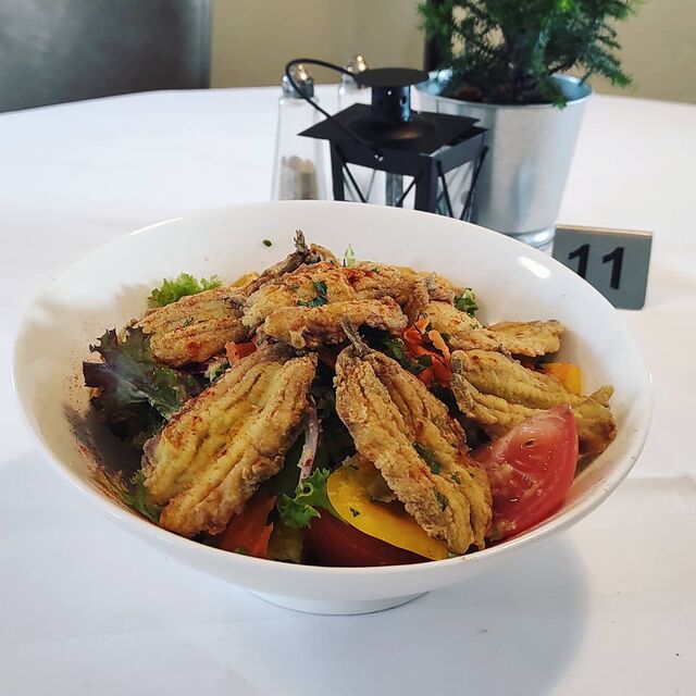 Panierte Sardellen auf Salat