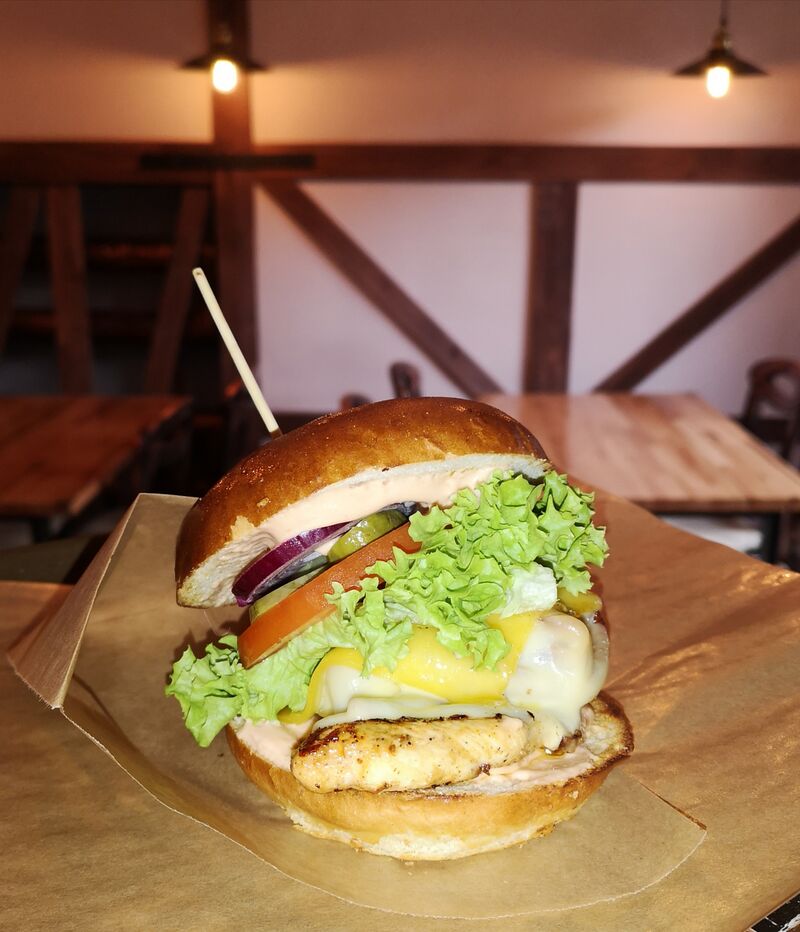 Country chiken burger ( grillowana pierś z kurczaka,bekon,cebulka czerwona,ogórek marynowany, pomidor,sałata,ser gouda,sosBBQ) 