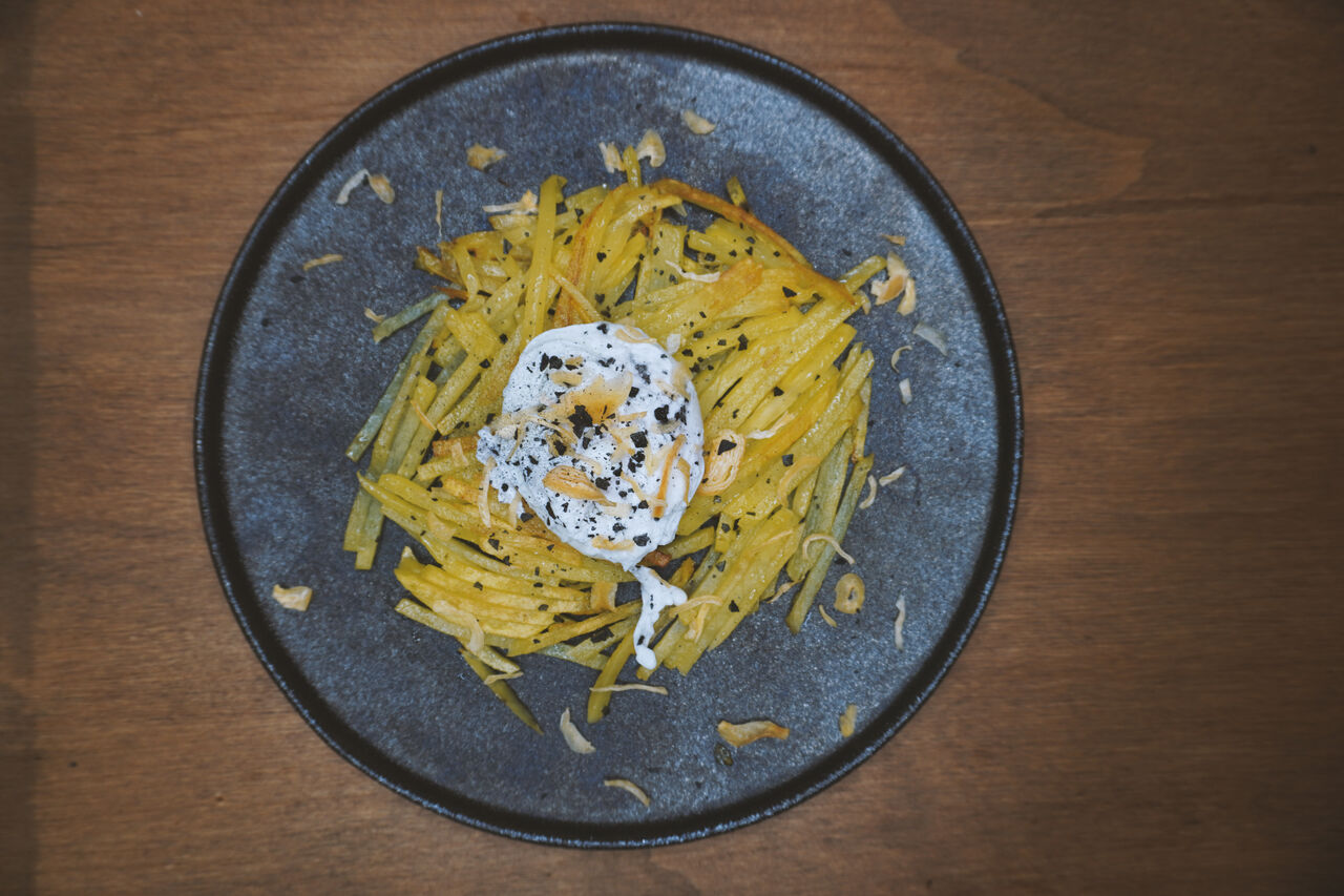 Uovo pochè su rosti di patate con cipolla essiccata e sale nero