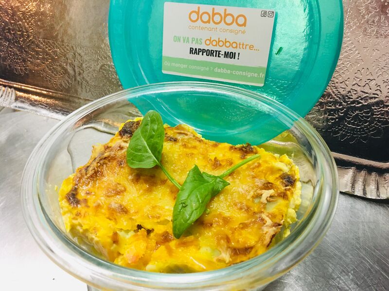 Gratin de ravioles-potimarron servi dans un récipient en verre dabba consigné.