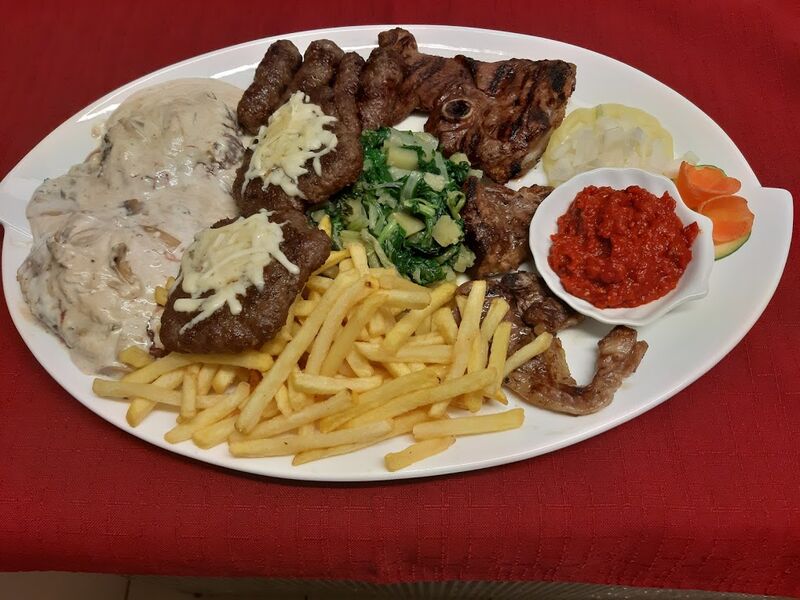 Meat platter which incude beefsteak with truffles sauce, lamb, cevapcici, steak of meal meat grilled on flaming lava stone.